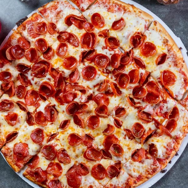 Close-up of a freshly baked, sliced pepperoni pizza from Grapevine Pizza & Cafe.